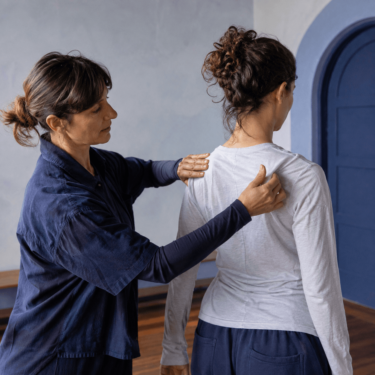 Teacher gently demonstrating a shoulder position to a student