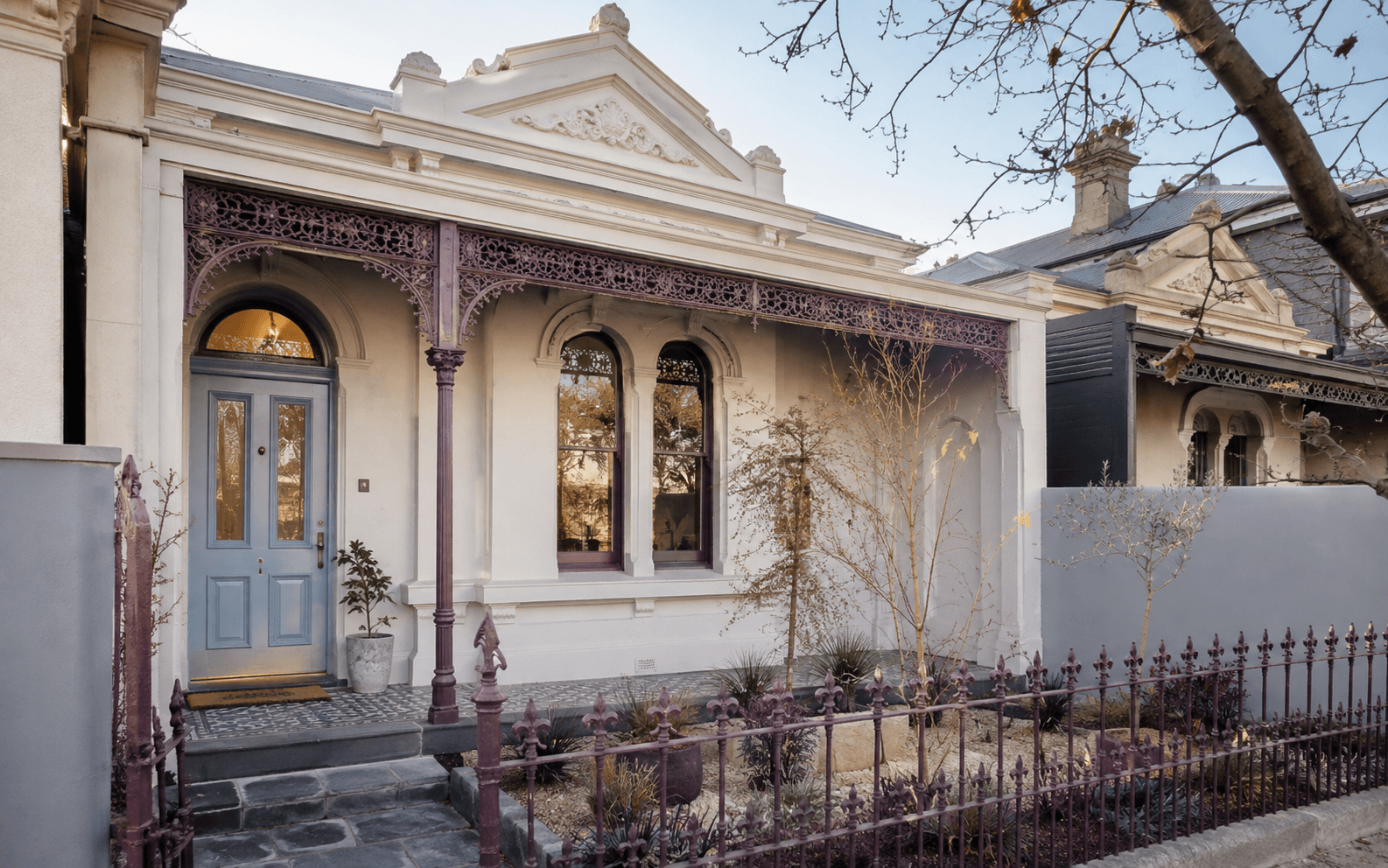Restored Carlton North Victorian terrace with a powder-blue door and plum ironwork
